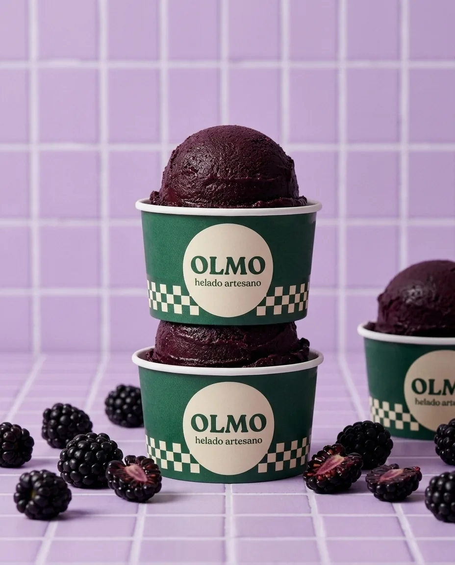 Cups of blackberry ice cream on lilac tiles.
